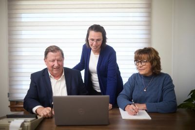 Erickson & Brooks team members collaborating around a laptop